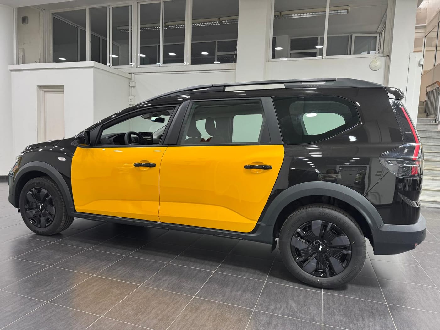 Lateral del Dacia Jogger taxi con puertas amarillas del taxi de Barcelona